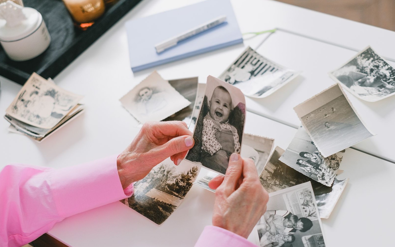 A person carefully organizing old black and white photographs